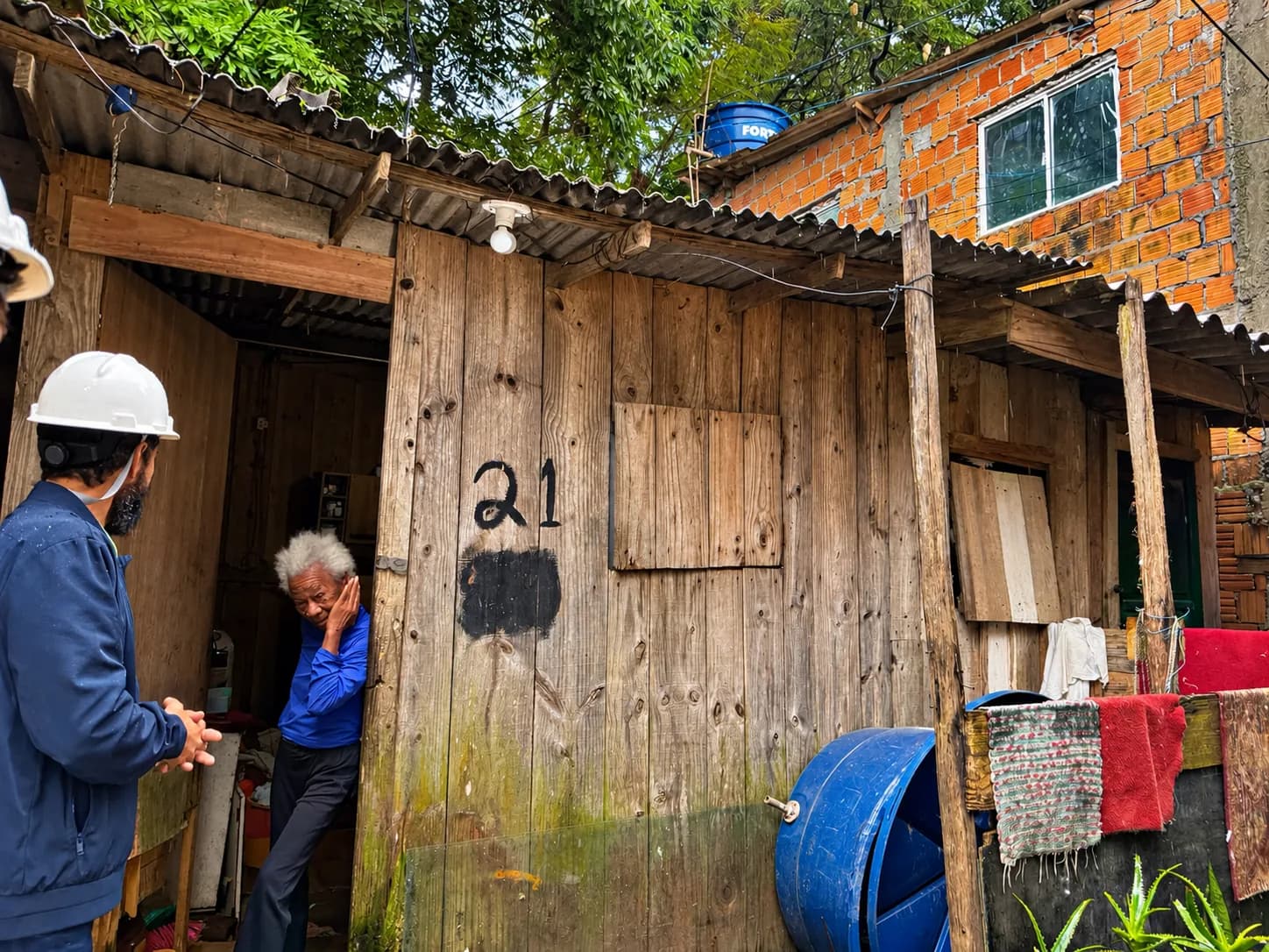 Dona Tereza conversa com um engenheiro da Tridium na porta de casa